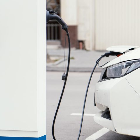 Side view car being charged electric vehicle charging station (1)